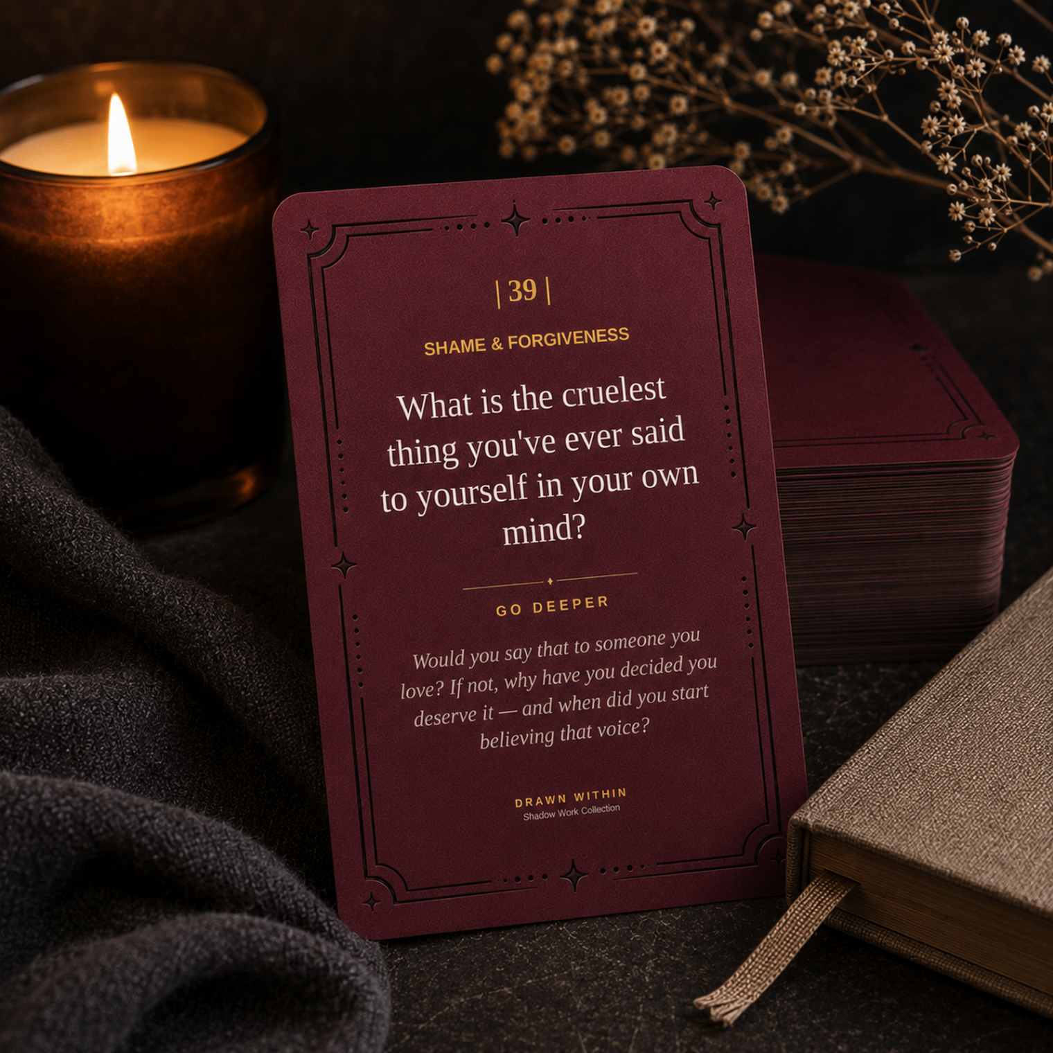 The Shadow Deck — a burgundy prompt card beside a candle and dried flowers